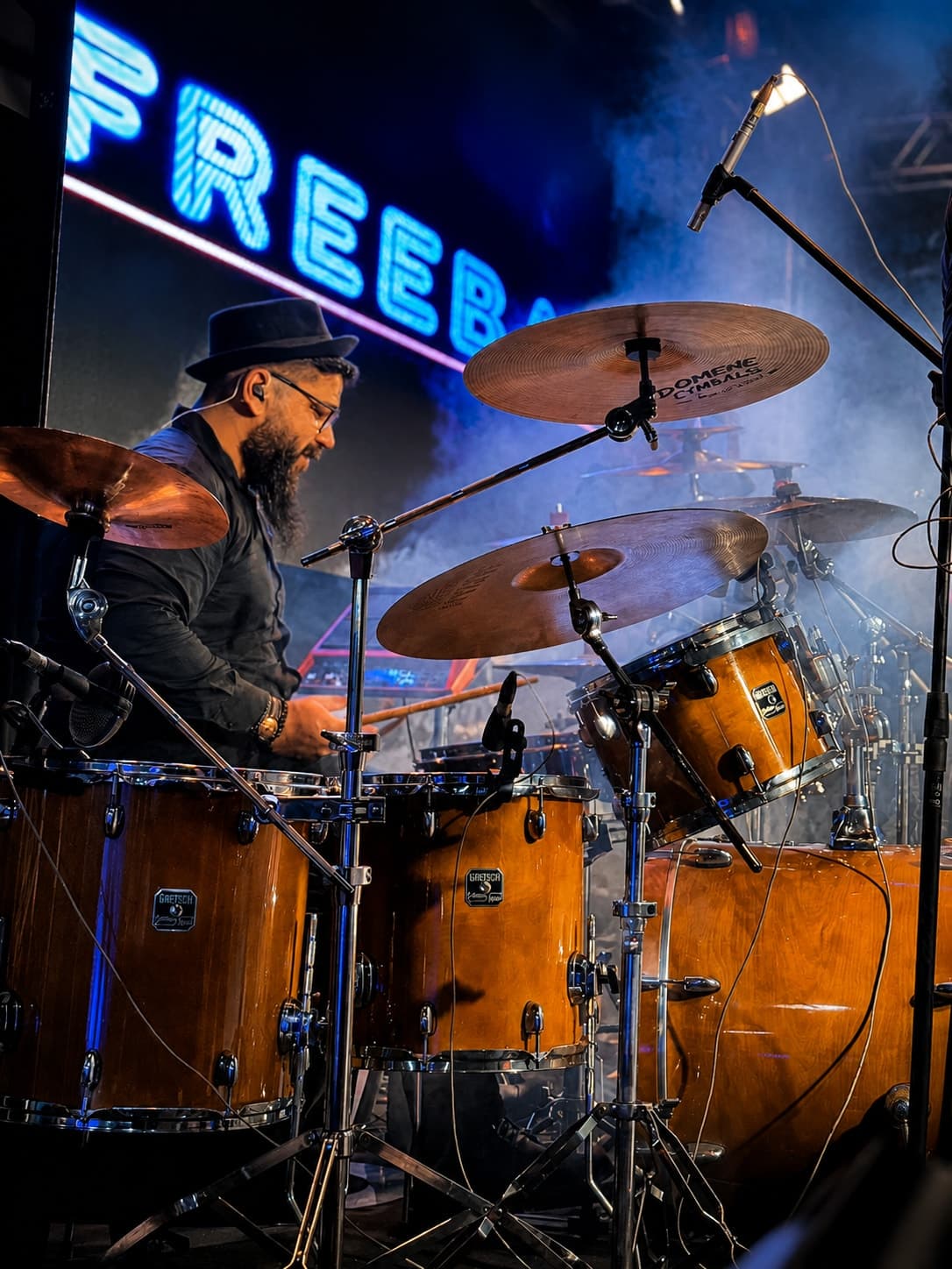 Baterista tocando diante do painel de LED aceso em neon