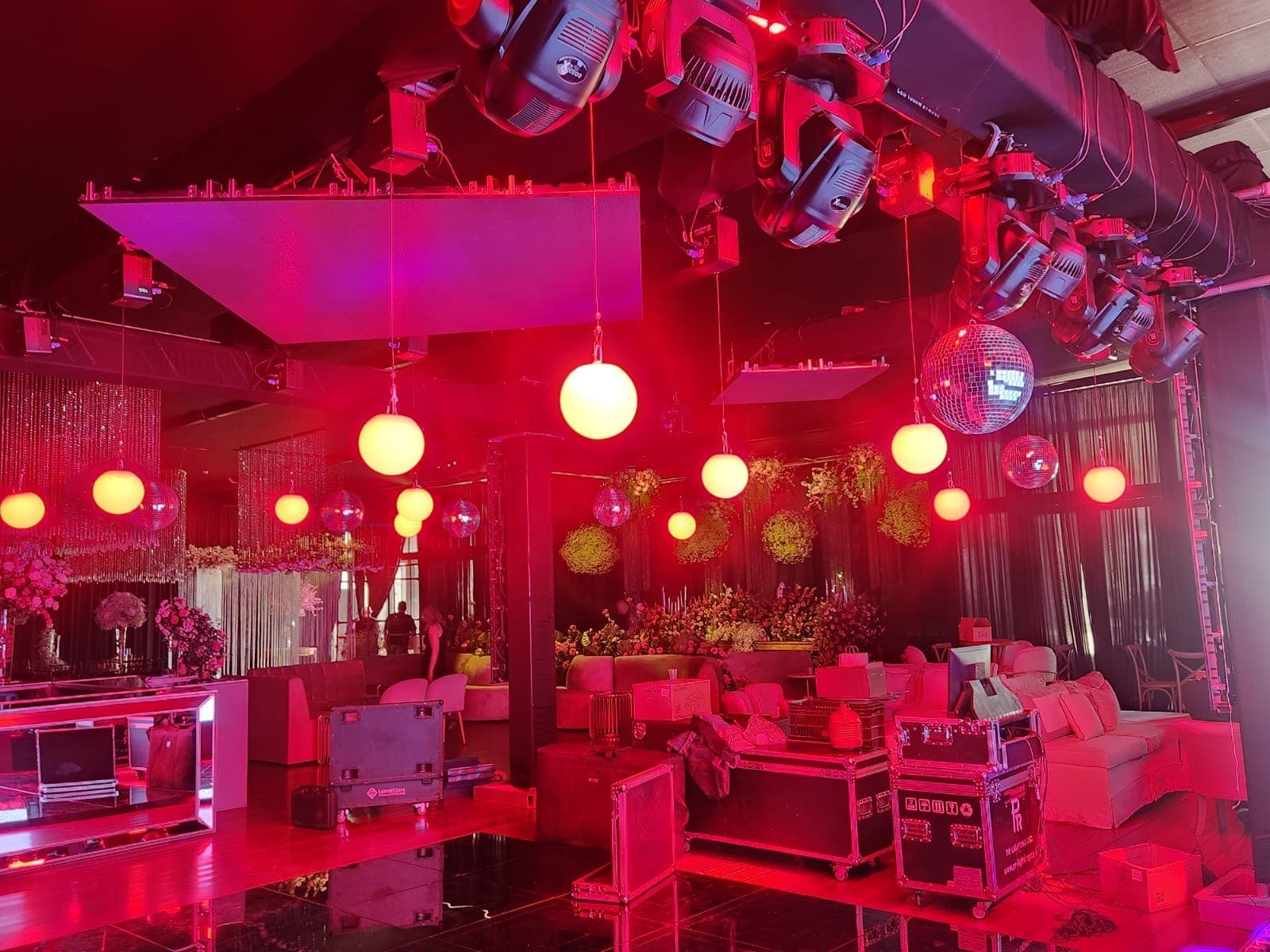 Salão de evento com moving heads, esferas de luz e globos espelhados instalados no teto